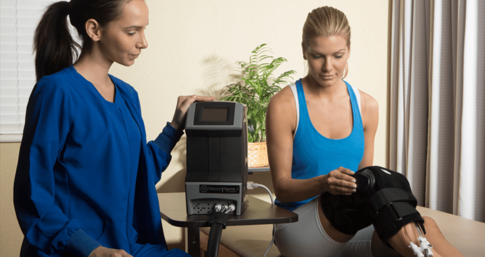 Healthcare provider demonstrating the VascuTherm 5 therapy device with a patient during a knee recovery session